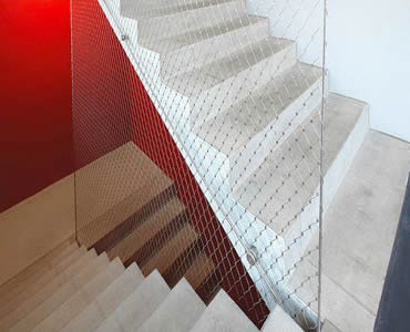 Stainless steel ferrule rope mesh is installed as the wall beside the stair.