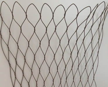 A piece of stainless steel knotted rope mesh hangs on the wall.