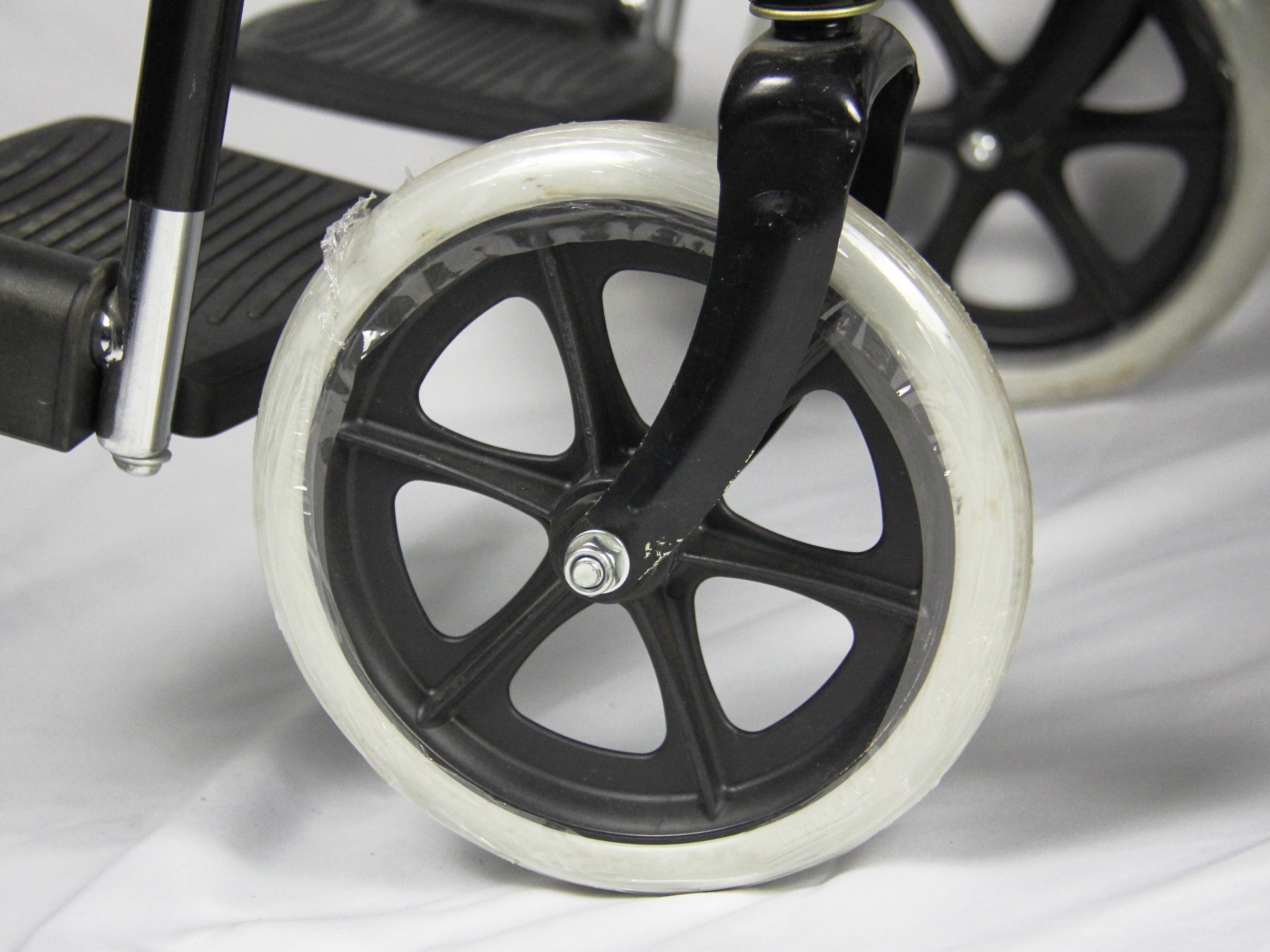 Low Price Basis Black Coating Steel Frame Folding Steel Wheelchair With Solid Wheel Fixed Armrest And Footrest