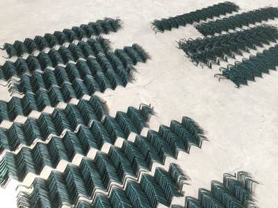 Folded green vinyl-coated chain link helideck mesh.