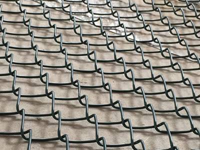 Unfolded green chain link helideck mesh fence.