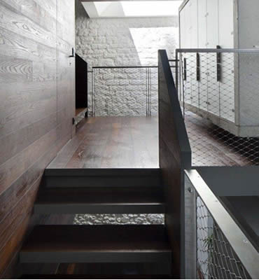 Stainless steel ferrule rope mesh is installed as balustrade infill of wooden stair.